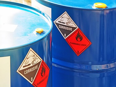 bulk-custom-chemical-solutions-barrels-18-1424 two large blue containers of corrosive flammable liquid chemicals